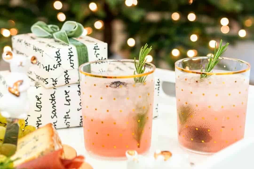 Holiday cocktails with pink hue and rosemary garnish at Type A Soiree.