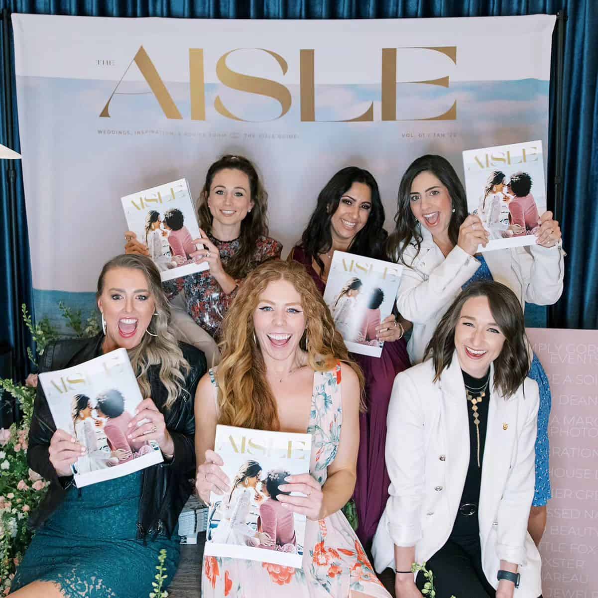 Group of women at Type A Soiree event holding magazines, smiling, indoor setting.