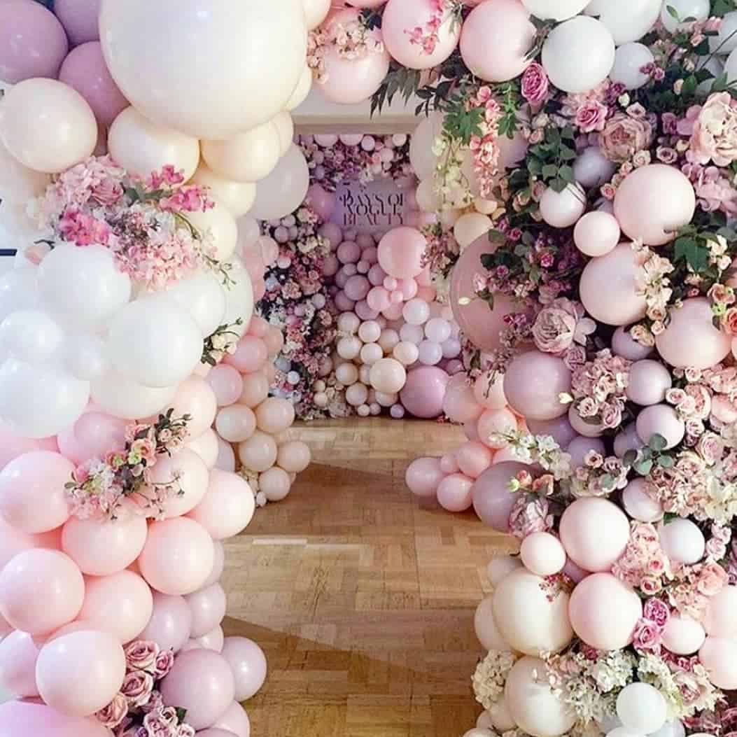 Beautiful pink and white balloon and flower arch for celebrations and parties.