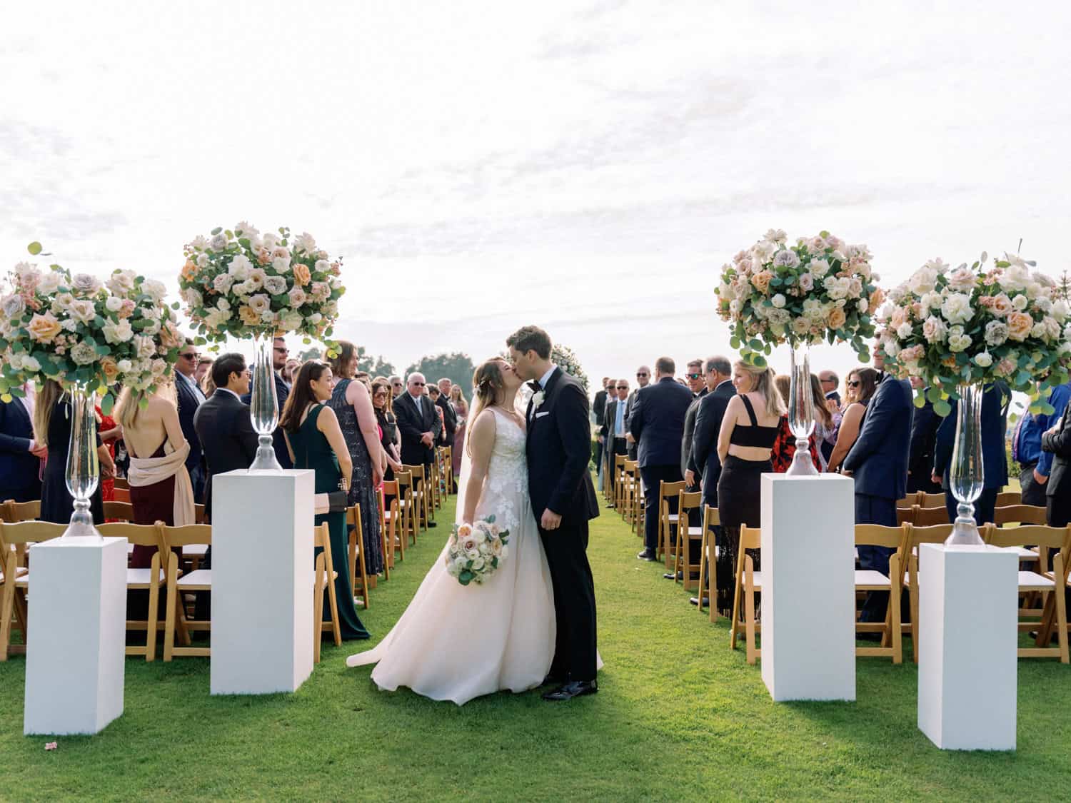 Wedding ceremony with floral decor, outdoor setting, and celebrating guests. Perfect for a romantic.