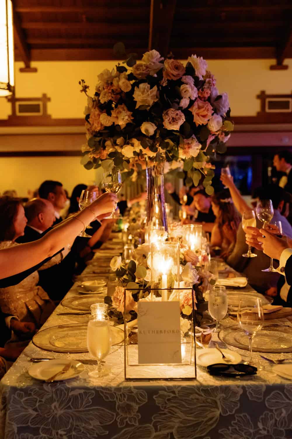 Beautiful floral centerpiece with candles at a formal dinner party.