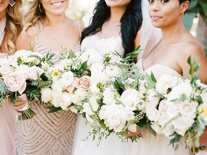 Bridal bouquet featuring white roses, peonies, and greenery at a wedding event.