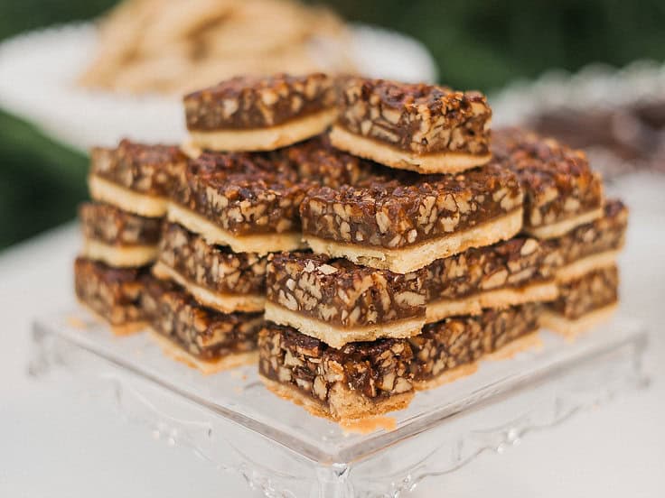 Delicious chocolate nut bar cookies stacked on a glass tray, perfect for a dessert or party treat.