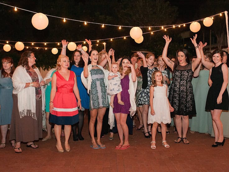 Outdoor party with guests dancing under string lights at a Type A Soiree event.