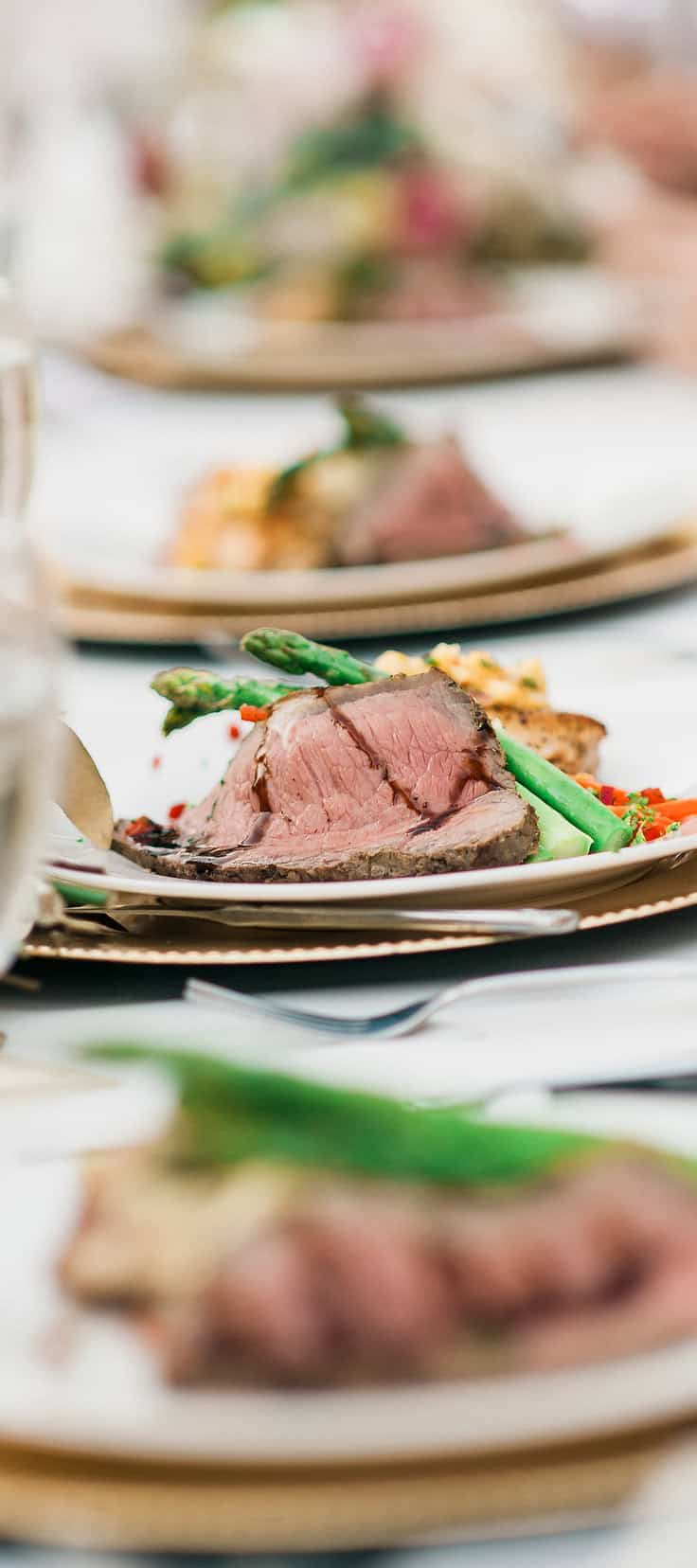 Beef tenderloin served with fresh asparagus and colorful vegetables at a sophisticated soirée.