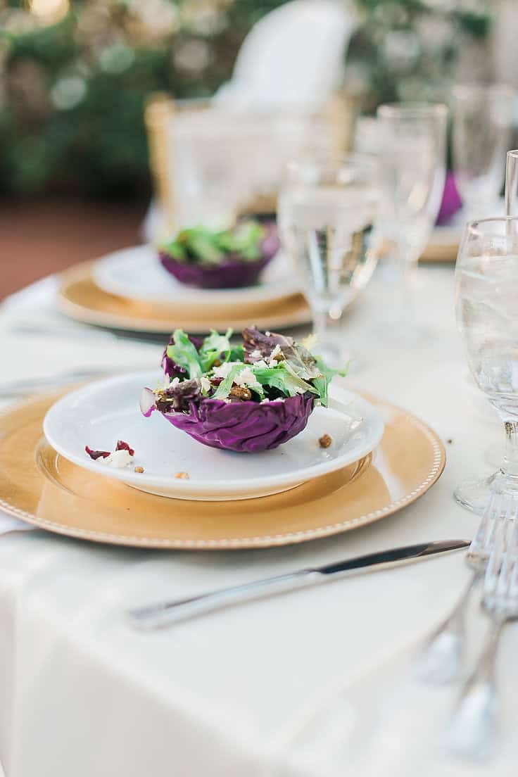 Elegant purple cabbage salad served on a white plate at a sophisticated outdoor dinner event.