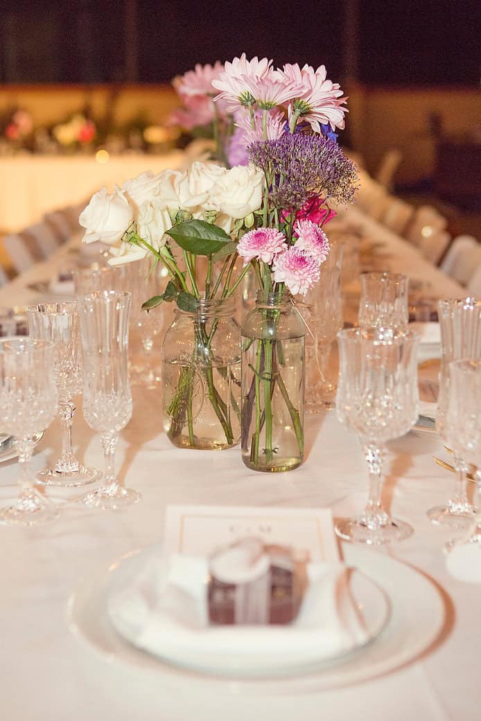 Beautiful flower arrangement with pink, white, and purple blooms on a formal dining table.